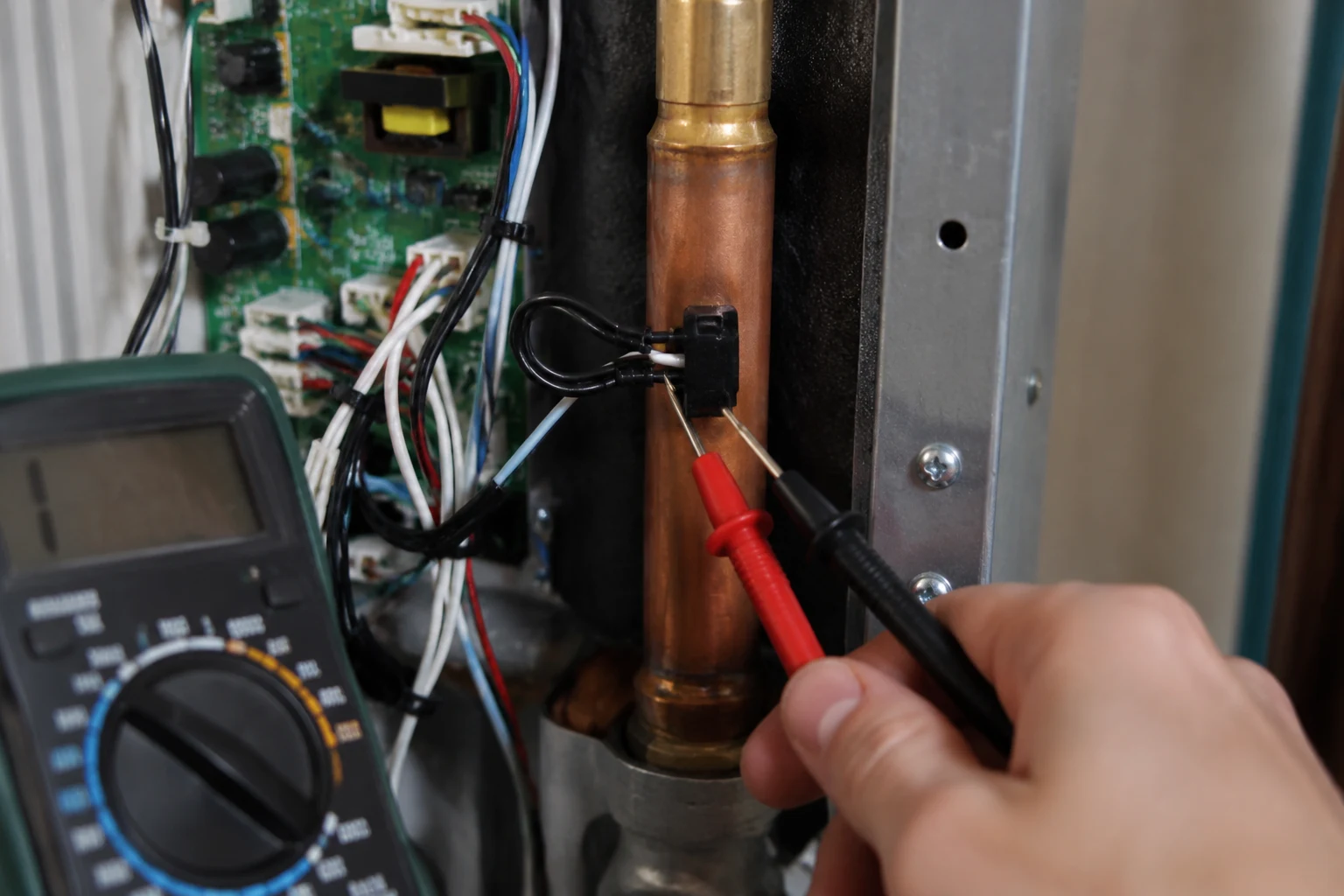 An EcoSmart tankless outlet thermistor connector being reseated inside the open cabinet with the breaker off