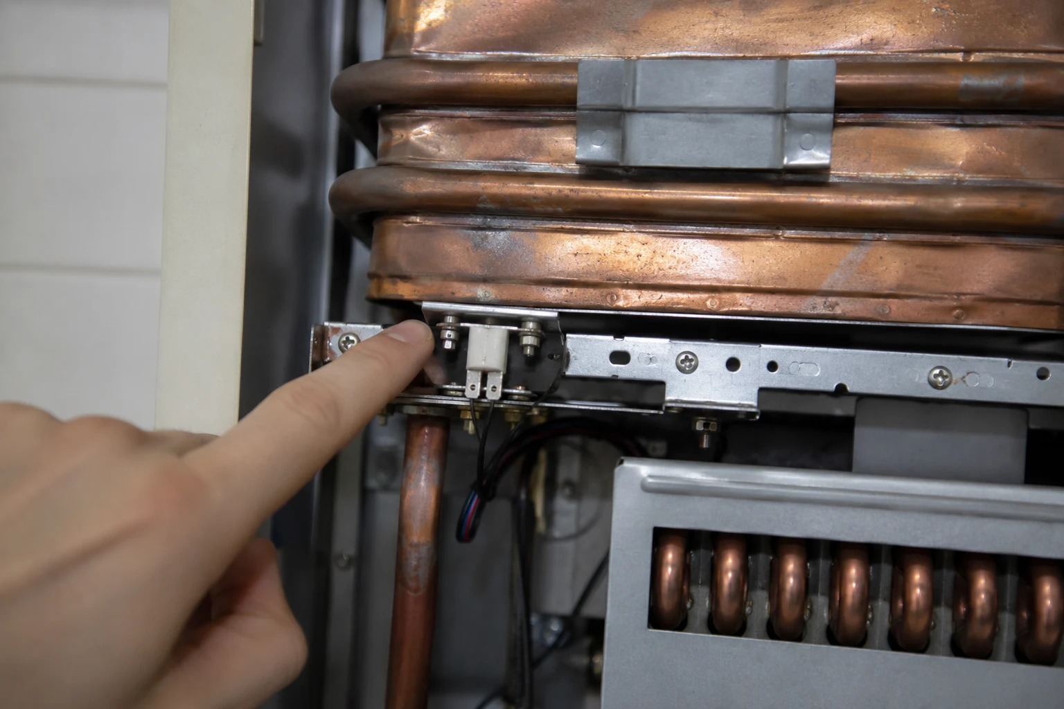 Technician flushing a Rinnai tankless water heater with a descaling pump connected to the service isolation valves to clear scale after a code 14