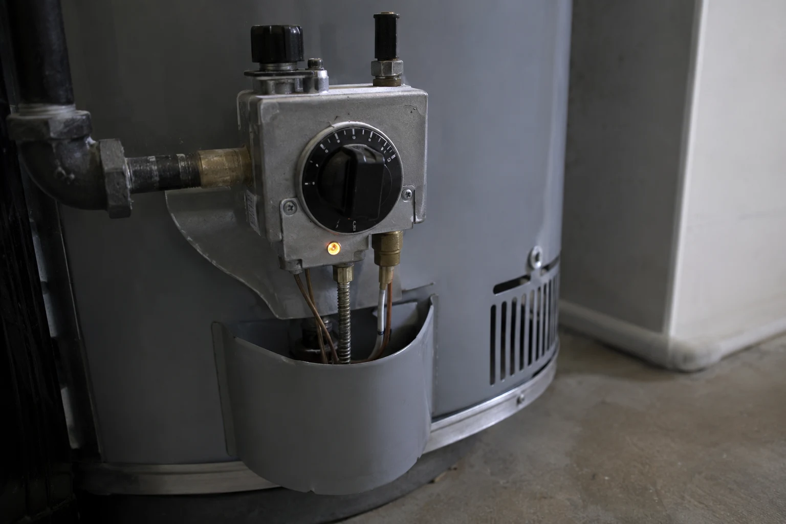 A Ruud residential storage water heater with the gas control valve and status light at the base, the temperature and pressure relief valve on the side, and the upper thermostat access panel, the spots a homeowner checks when troubleshooting