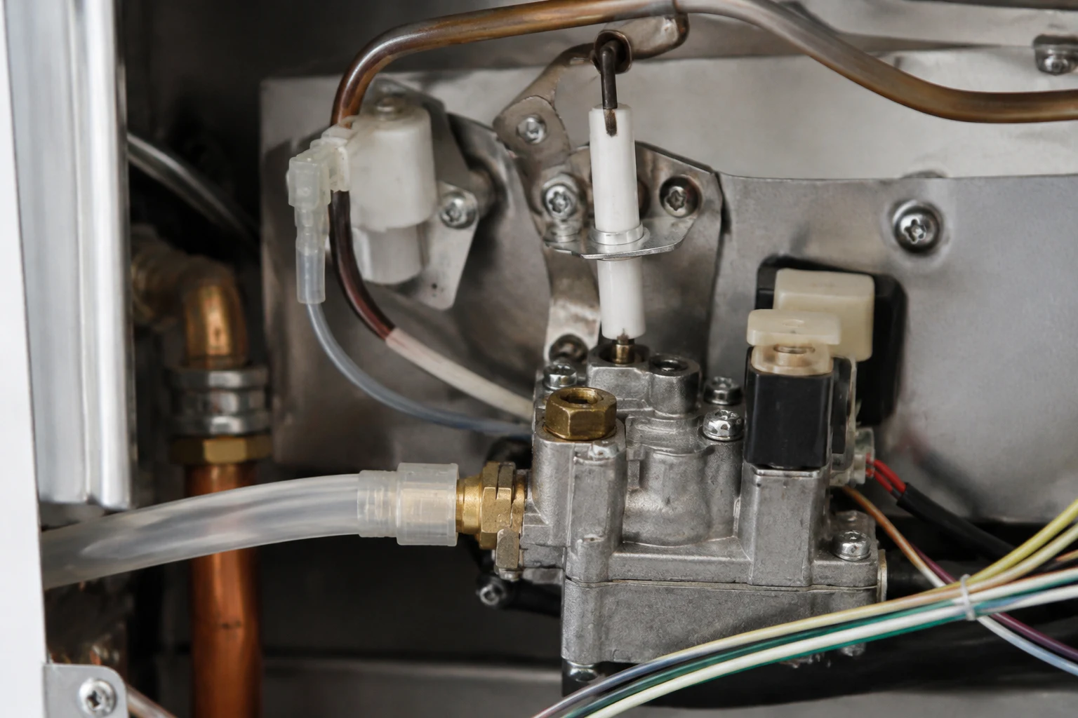 Technician inspecting the burner and flame rod inside an opened Takagi tankless unit during a code 111 repair